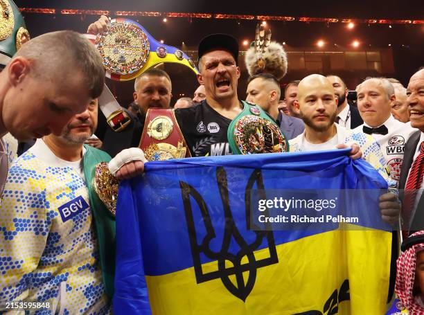 Oleksandr Usyk holds a Ukrainian flag as he celebrates with the Undisputed Heavyweight title belt following victory over Tyson Fury in the IBF, WBA,...