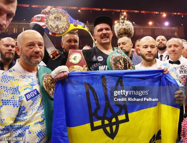 Oleksandr Usyk holds a Ukrainian flag as he celebrates with the Undisputed Heavyweight title belt following victory over Tyson Fury in the IBF, WBA,...