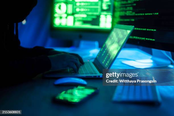 computer hacker coding on keyboard on a background of monitors. - russian ethnicity stock pictures, royalty-free photos & images