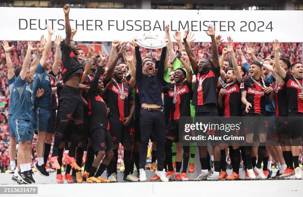 Xabi Alonso Head coach of Bayer Leverkusen, lifts the Meisterschale of Bundesliga trophy after his team's victory during the Bundesliga match between...