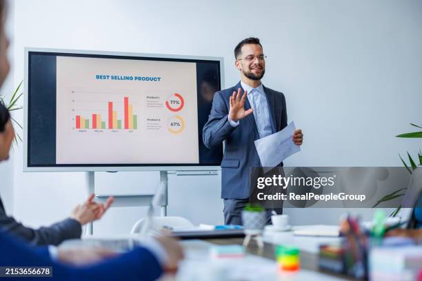 smiling businessman presenting data on screen - work performance stock pictures, royalty-free photos & images