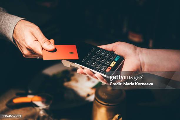 man pays with a card in a cafe. - carte da gioco foto e immagini stock