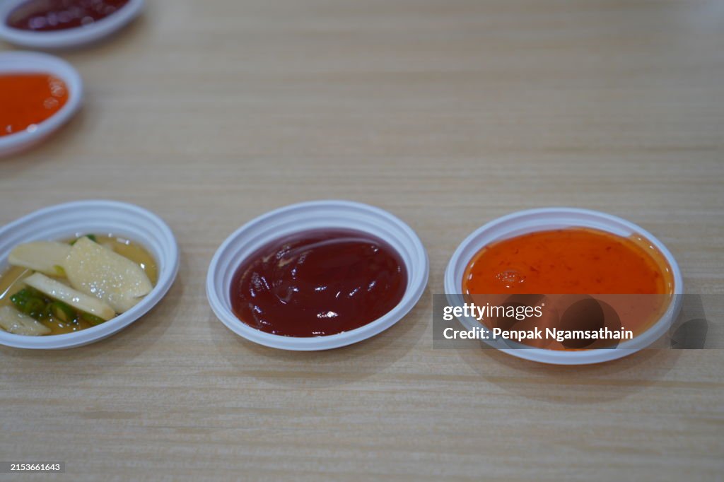 Tomato sauce with chili sauce in white plastic bowl on table