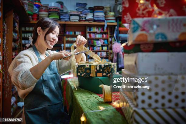 one asia female craftsperson wrapping gift box - kado inpakken stockfoto's en -beelden