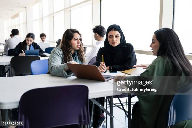 saudische frauen diskutieren klassenarbeit im studiersaal - chancengleichheit stock-fotos und bilder
