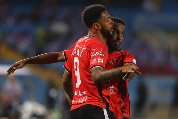 Riyadh's English forward Andre Gray celebrates with a teammate after scoring their first goal during the Saudi Pro League football match between...