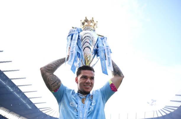 Ederson of Manchester City. Celebrates with the Premier League Trophy after their team's victory.