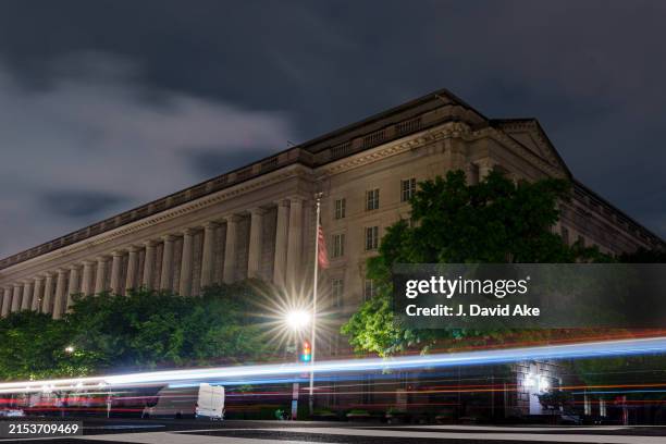 Traffic streaks past the Internal Revenue Service headquarters building late in the evening on May 18, 2024 in Washington, DC.