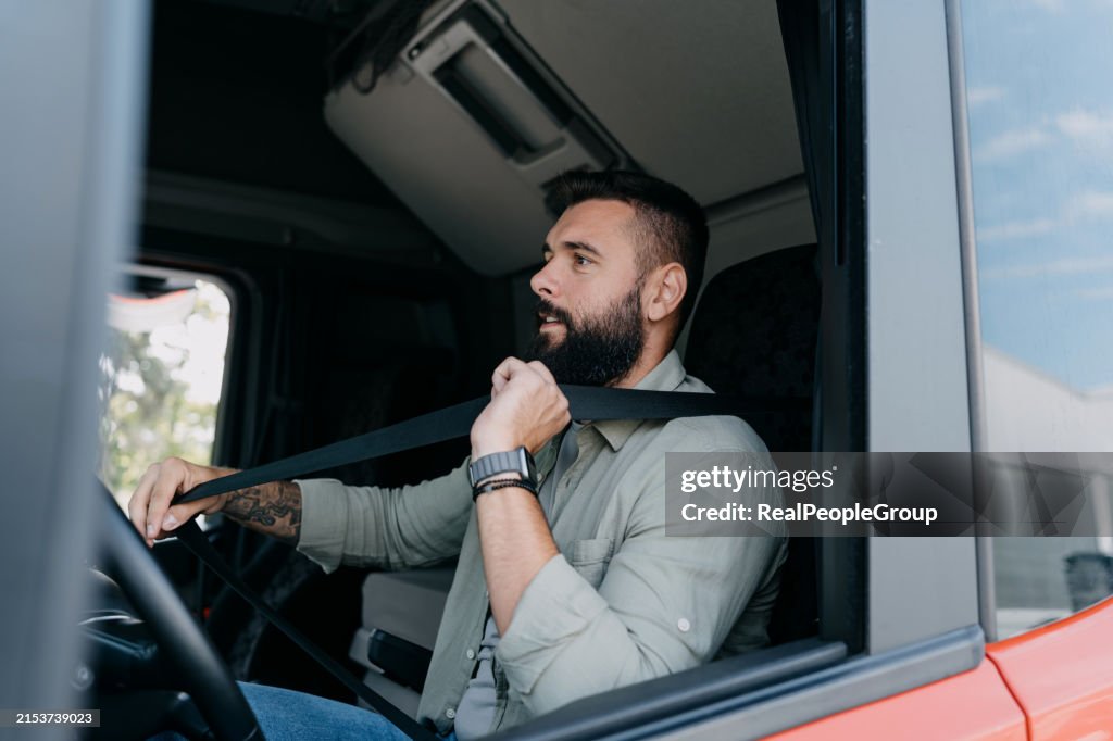 Truck driver buckling up before driving