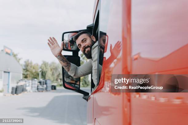 truck driver waving from vehicle - truck driver stock pictures, royalty-free photos & images
