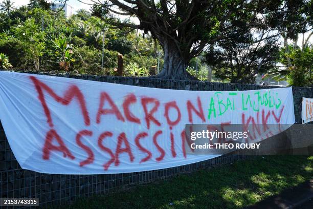 This picture shows banners set up along a road following a visit by French President Emmanuel Macron in Noumea, France's Pacific territory of New...