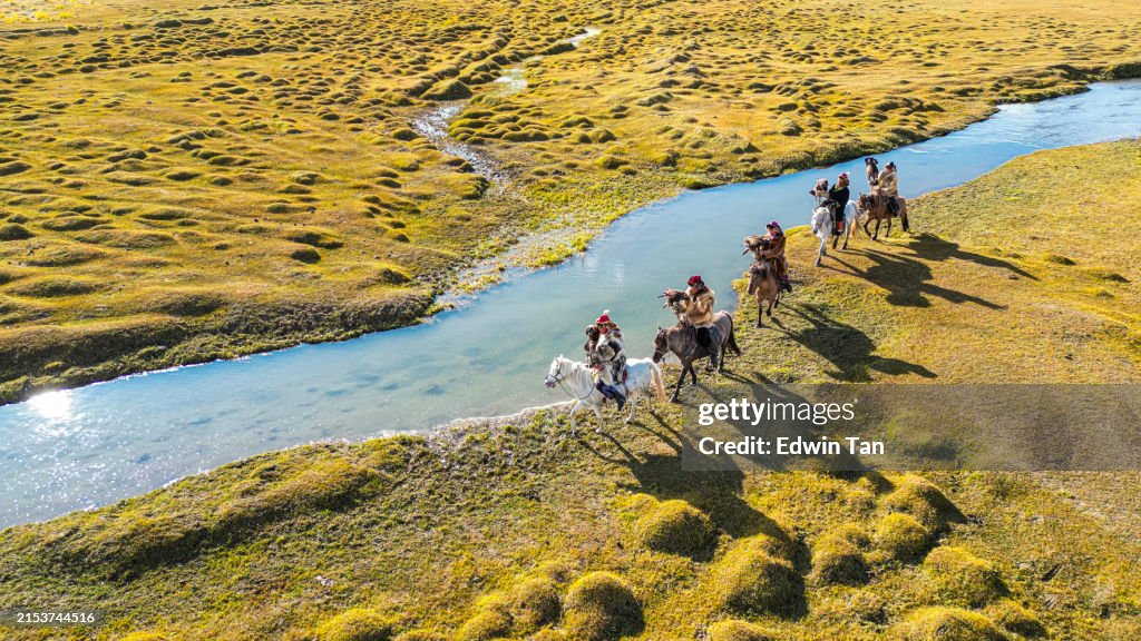 Gruppe kasachischer Adlerjäger auf Pferden entlang des Flusses Bayan Olgii, Westmongolei