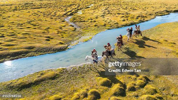 gruppe kasachischer adlerjäger auf pferden entlang des flusses bayan olgii, westmongolei - mongolei stock-fotos und bilder