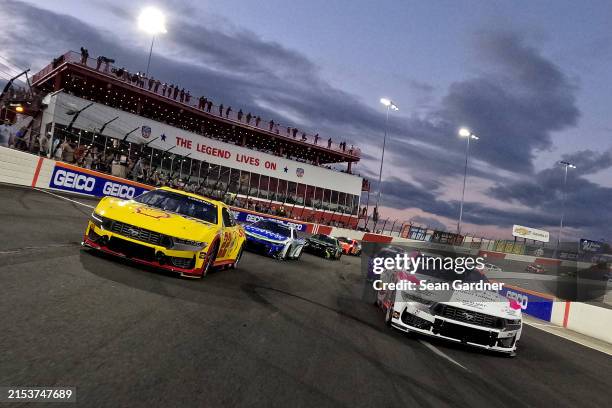 Joey Logano, driver of the Shell Pennzoil Ford, and Brad Keselowski, driver of the Nexlizet Ford, lead the field on a pace lap prior to the NASCAR...