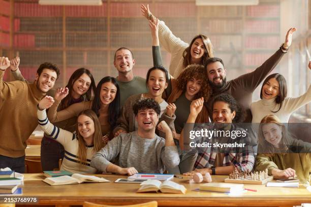 happy diverse students celebrating success in library. - the end stock pictures, royalty-free photos & images