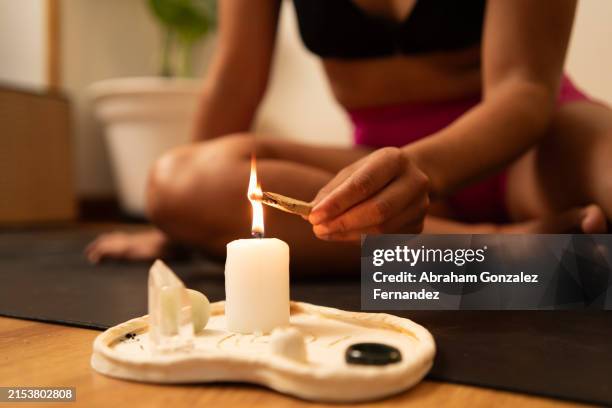 girl burns a palo santo stick with a candle - ceremony stock pictures, royalty-free photos & images