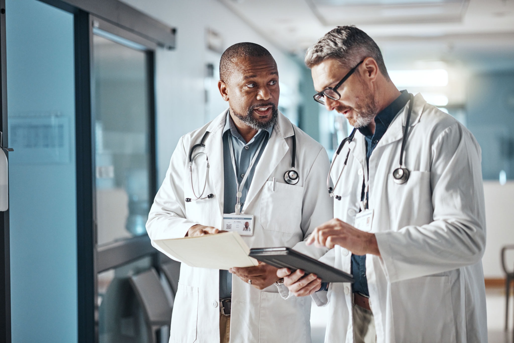 Hospital, trabalho em equipe e médicos com folder, tablet e brainstorming para saúde e administração. Médico, líder e profissional sênior com tecnologia e reunião com documentos e compartilhar informações Hospital, trabalho em equipe e médicos com folder, tablet e brainstorming para saúde e administração. Médico, líder e profissional sênior com tecnologia e reunião com documentos e compartilhar informações