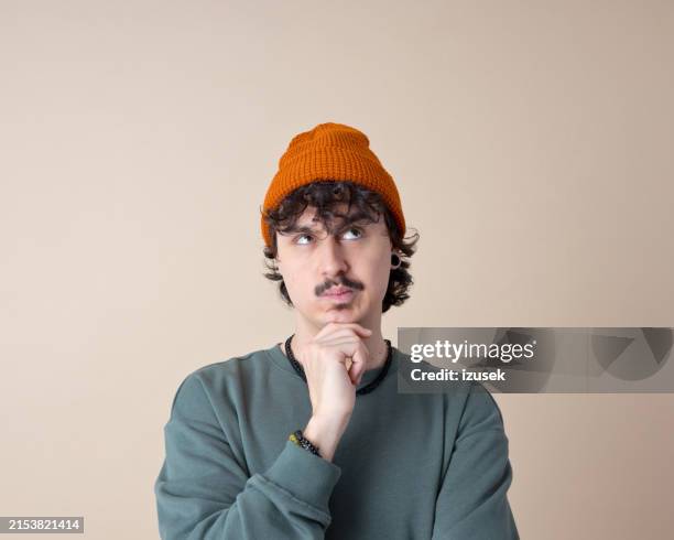 headshot of thoughtful young man - confusion stock pictures, royalty-free photos & images