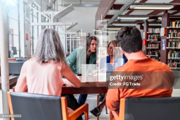 coworkers analyzing virtual projection of buildings - virtual library stock pictures, royalty-free photos & images