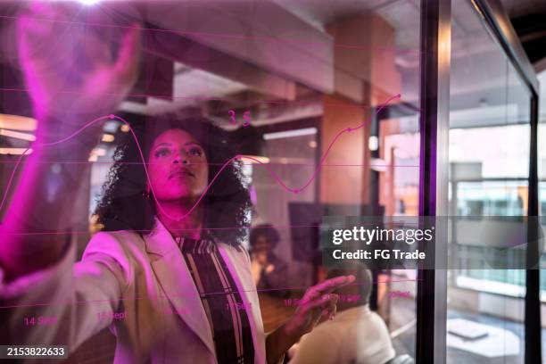 junge geschäftsfrau mit augmented-reality-gerät im büro - data science stock-fotos und bilder