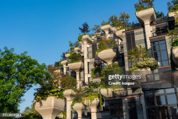 vertical greening of modern urban buildings - groen dak stockfoto's en -beelden
