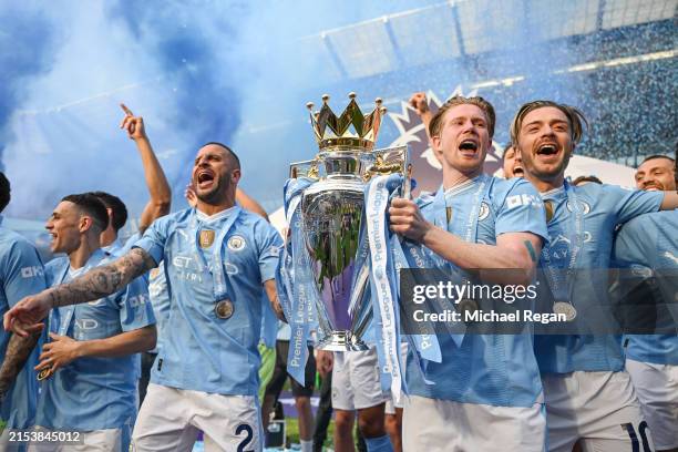 Kyle Walker, Kevin De Bruyne and Jack Grealish lift the Premier League trophy after the Premier League match between Manchester City and West Ham...