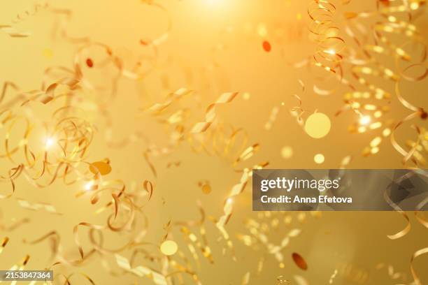 falling golden serpentine and confetti on golden background. festive monochrome backdrop. three dimensional illustration - stage decoration stock pictures, royalty-free photos & images