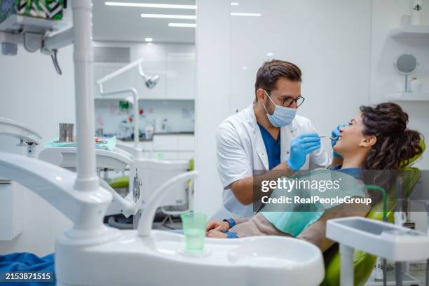 dentist performing a checkup on patient - tandarts stockfoto's en -beelden