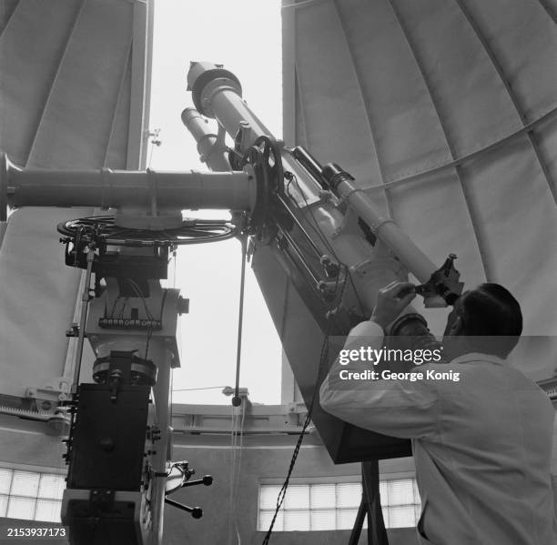 Senior experimental officer HHJ Barton using a photoheliograph attached to the refractor to take an exposure of the sun, through the roof of the dome...