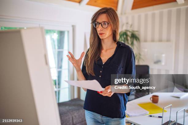 focused woman rehearsing her speech at home - monologue stock pictures, royalty-free photos & images