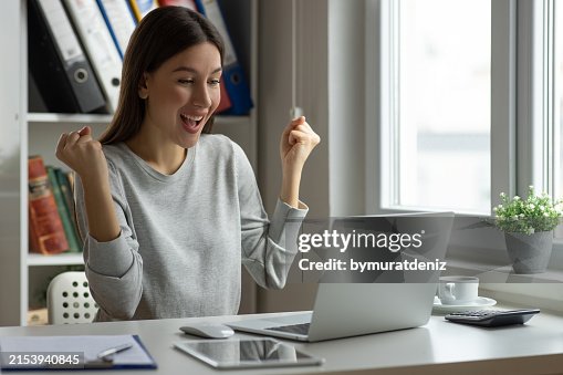 Celebrating an achievement while using her laptop Celebrating an achievement while using her laptop