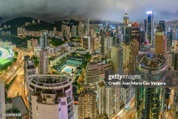 city life downtown hong kong with its vibrant cityscape skyline glittering in the wan chai area at night, hong kong - victoria park hong kong stock pictures, royalty-free photos & images