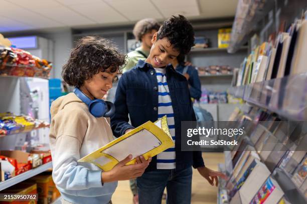 brothers picking a book at the airport - brother stock pictures, royalty-free photos & images