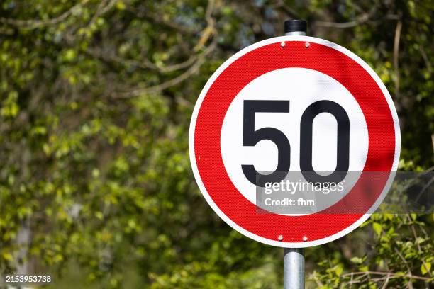 german traffic road sign: speedlimit 50 with nature in background - número 50 imagens e fotografias de stock