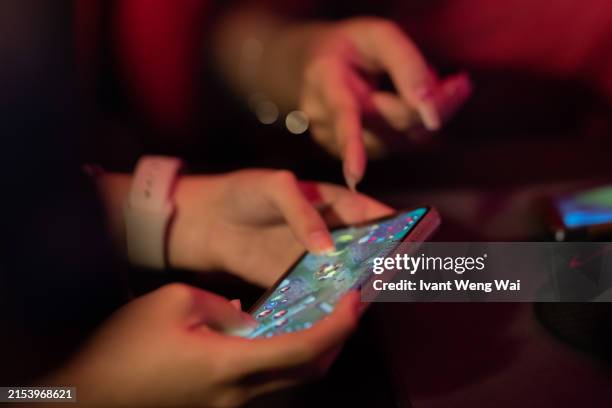 asian female gamer in smart phone game - malaysia games stock pictures, royalty-free photos & images