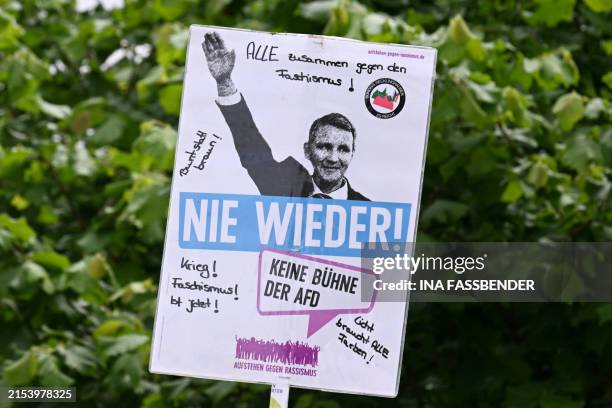 Demonstrator holds up a placard reading 'Never again - no stage for AfD' during a protest against the electoral campaign meeting of the far-right AfD...