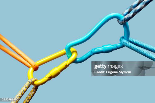 3d render a closeup of two colorful carabiners connected by ropes on a blue background. - confiança imagens e fotografias de stock