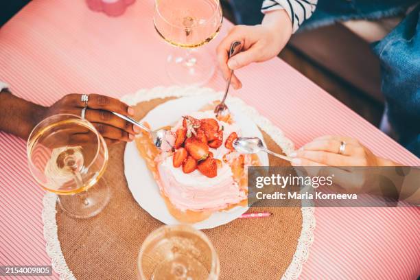 three girlfriends sharing a cake together. - dessert foto e immagini stock