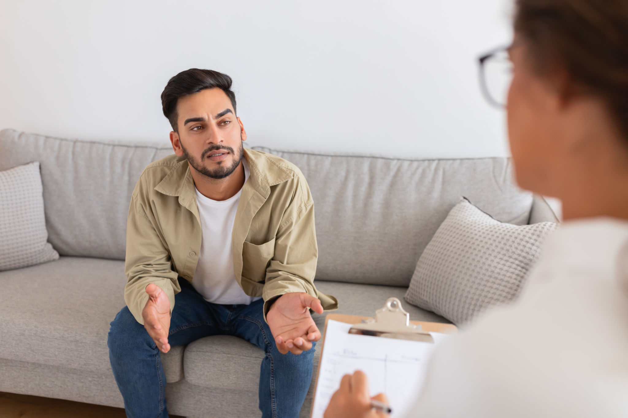 Middle eastern man speaking with therapist on couch Middle eastern man speaking with therapist on couch