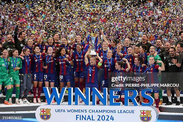 Barcelona's players celebrate with the trophy after winning the UEFA Women's Champions League final football match between FC Barcelona and Olympique...