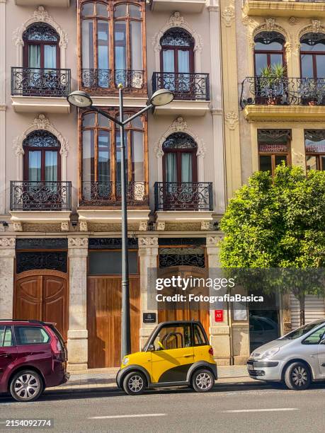 yellow compact electric car parked in the street - carro compacto imagens e fotografias de stock