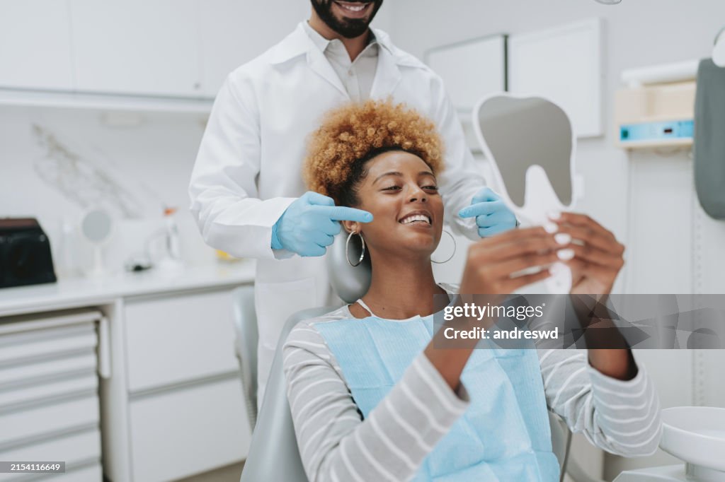 Woman at dentist holding mirror