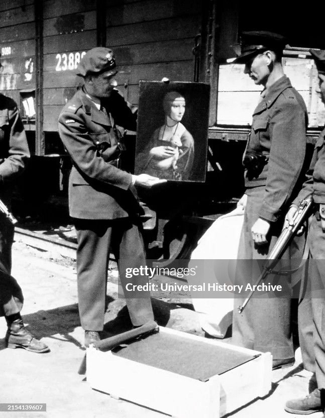 Monuments men stand with Leonard da Vinci's 'Lady with an Ermine' upon its return to Poland in April 1946.