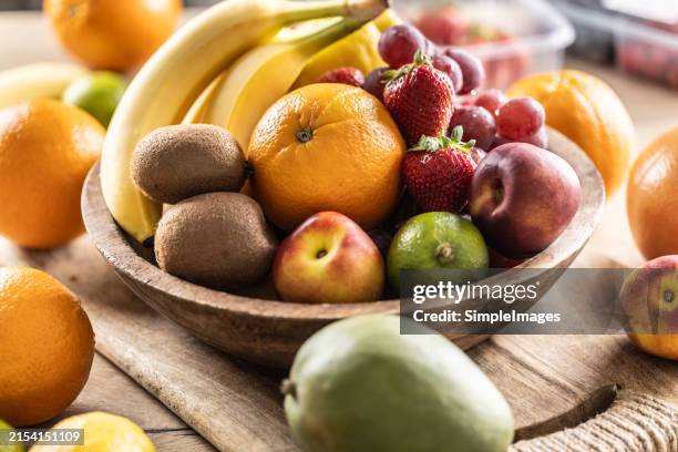 fresh fruit in a wooden bowl. concept of healthy nutrition. - obstschale stock-fotos und bilder