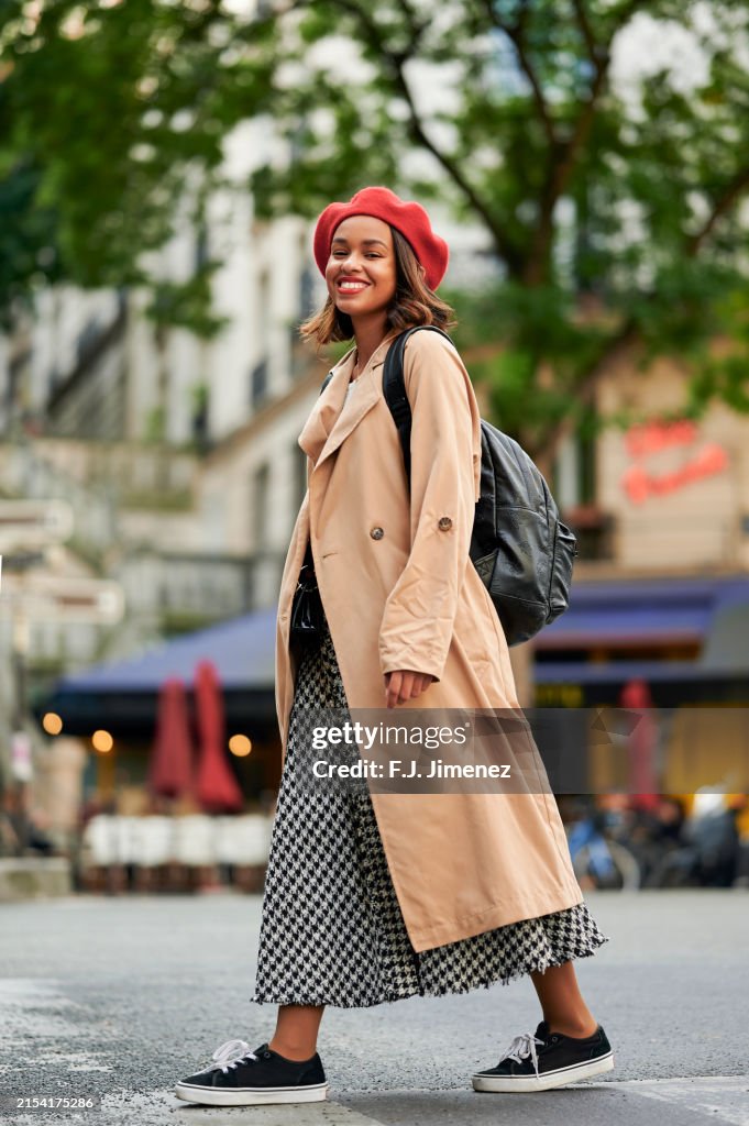 Woman in trench coat walking down Paris street