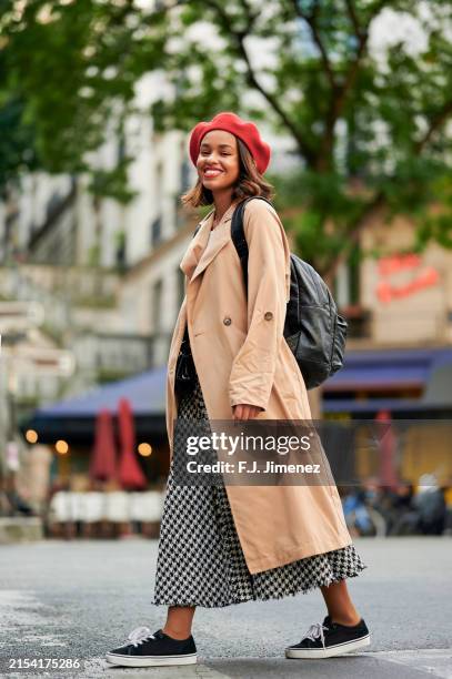 woman in trench coat walking down paris street - beret stock pictures, royalty-free photos & images