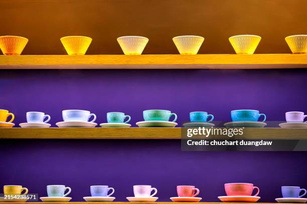 various color tea cups on wooden shelf - porcelain stock pictures, royalty-free photos & images