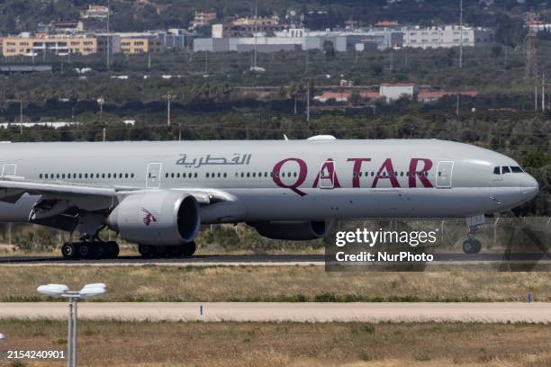 Qatar Airways Boeing 777-300ER passenger airplane as seen on final approach flying, landing and taxiing at Athens International Airport ATH in the...