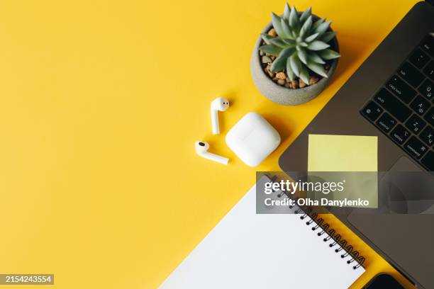 laptop, flower, sticker, headphones on a bright yellow background. the desktop of a freelancer, businesswoman or manager - table top view stock pictures, royalty-free photos & images