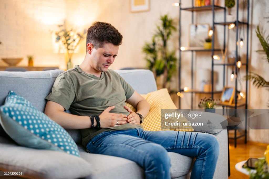 Young Man Having Stomach Pain At Home